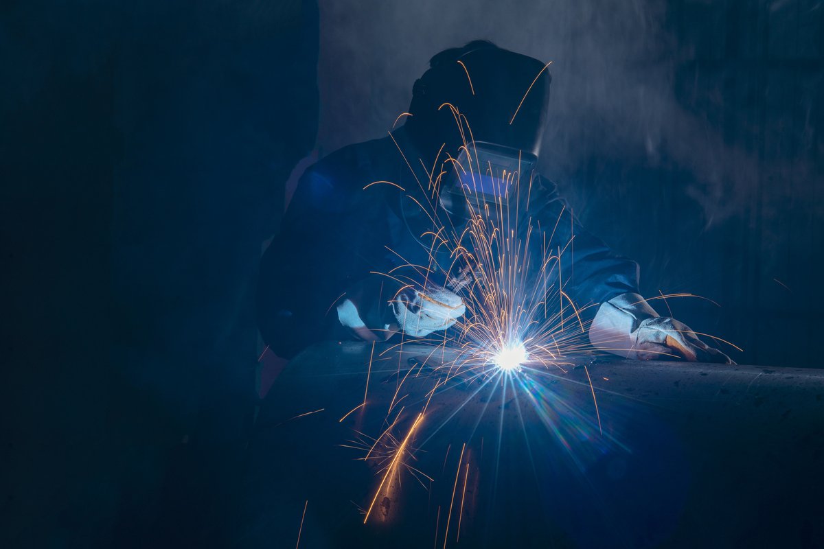 Professional welder and mask welding metal pipe.