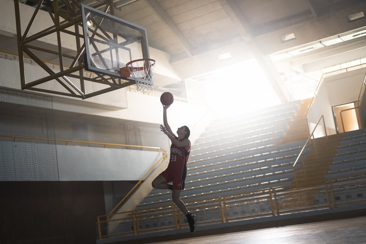 Young woman throwing basketball towards basket