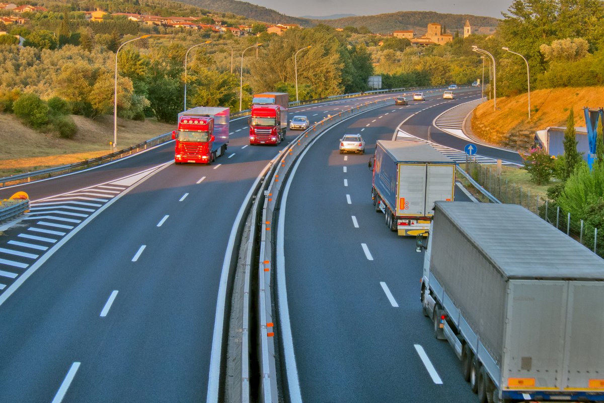 Italian motorway, trucks travelling, green hills around