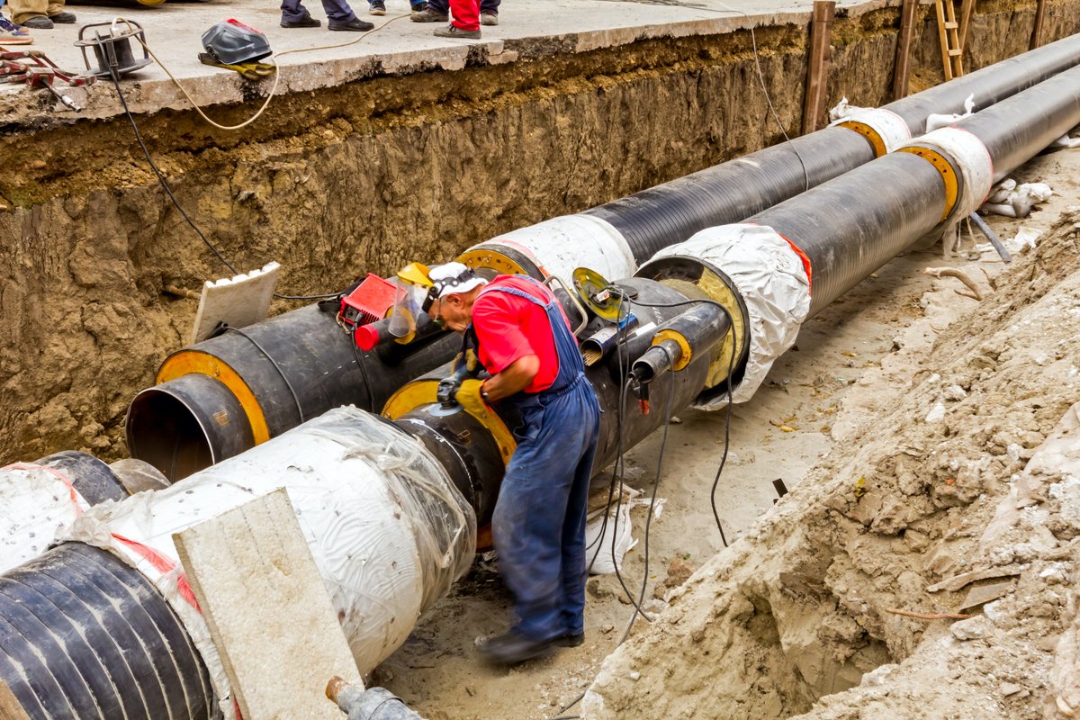 Male worker preparing to weld a large pipeline