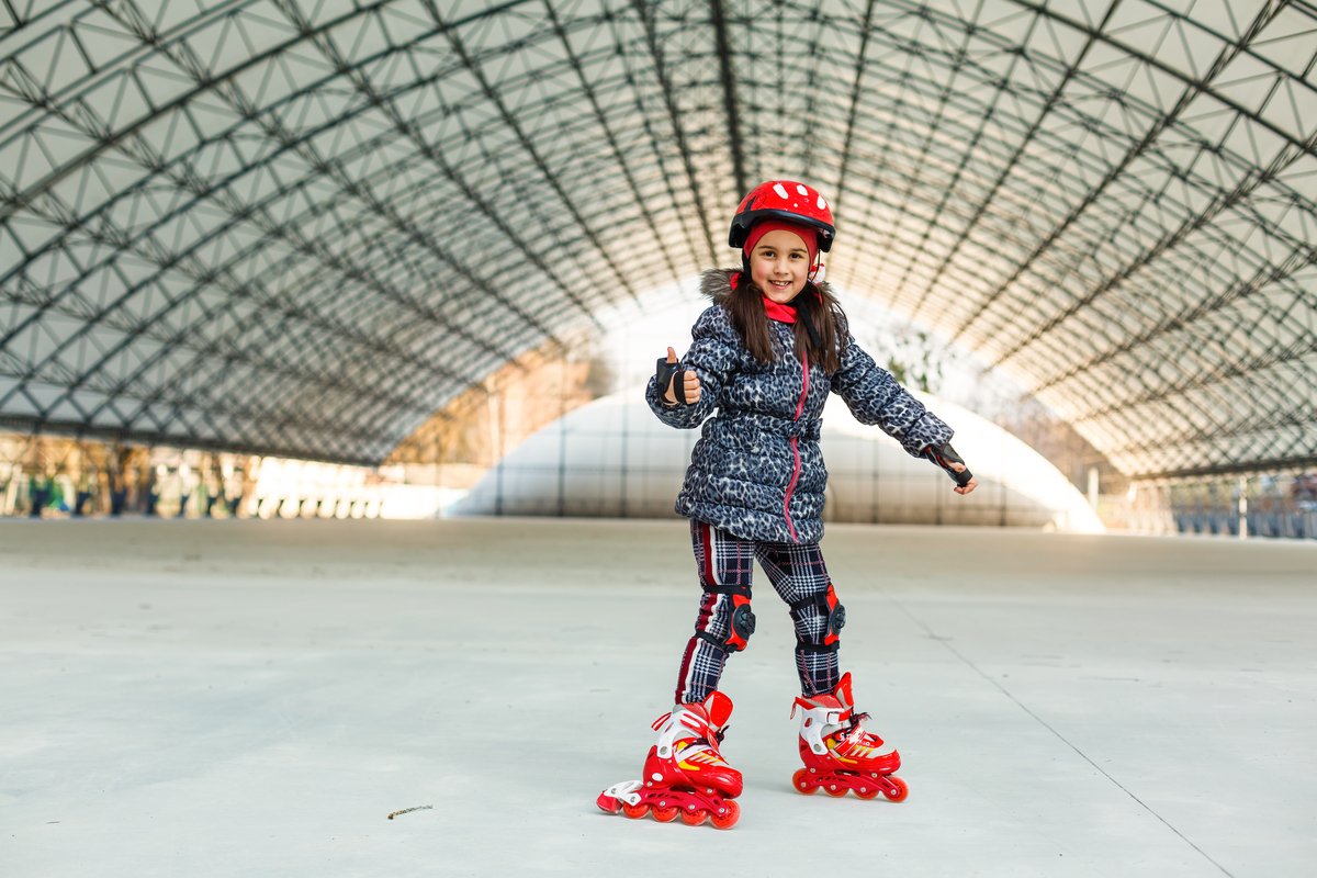 little girl rollerblading on roller rink